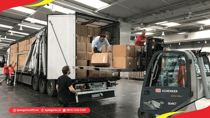 Truk trailer dengan pallet cargo dan forklift di area loading dock gudang