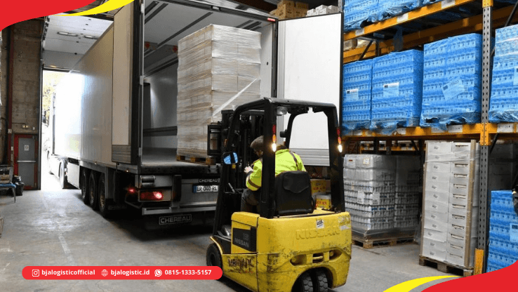 Proses loading cargo menggunakan forklift ke dalam truk di area gudang