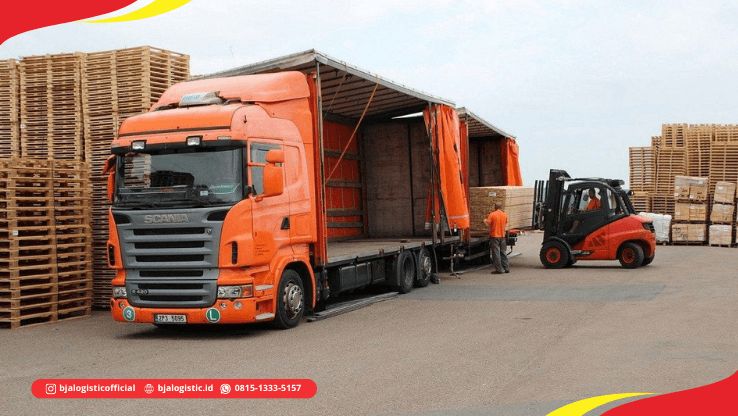 Truk cargo dengan pallet dan hand pallet truck di area loading dock untuk pengiriman darat