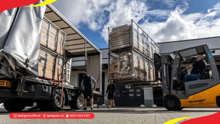 Forklift memindahkan pallet cargo ke truk di area loading dock untuk pengiriman darat