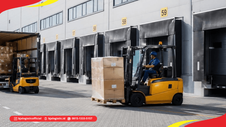 Forklift memindahkan pallet cargo ke truk di loading dock untuk pengiriman darat dari Jakarta ke Karanganyar